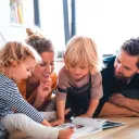 Uma família olhando para um livro.