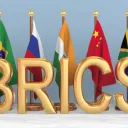 Letras da sigla BRICS com bandeiras dos países-membros ao fundo