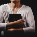 Uma mulher segurando a Bíblia.