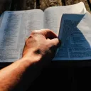 Um homem folheando uma Bíblia.