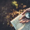 Uma pessoa segurando uma bússola e um mapa.