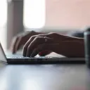 Mãos digitando na máquina de escrever.