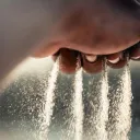 Areia escorrendo da mão de uma pessoa.