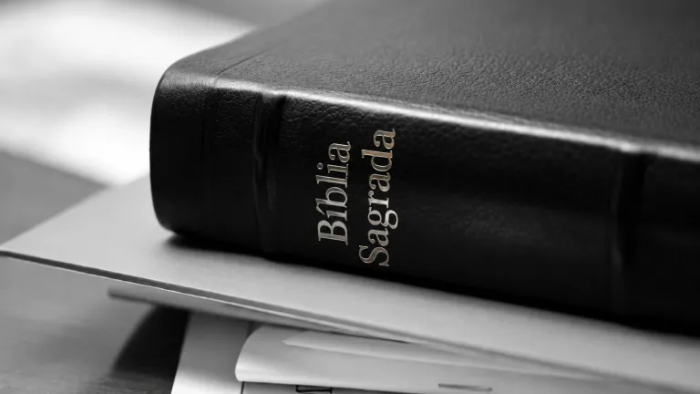 Bíblia empilhada sobre uma pilha de papéis.