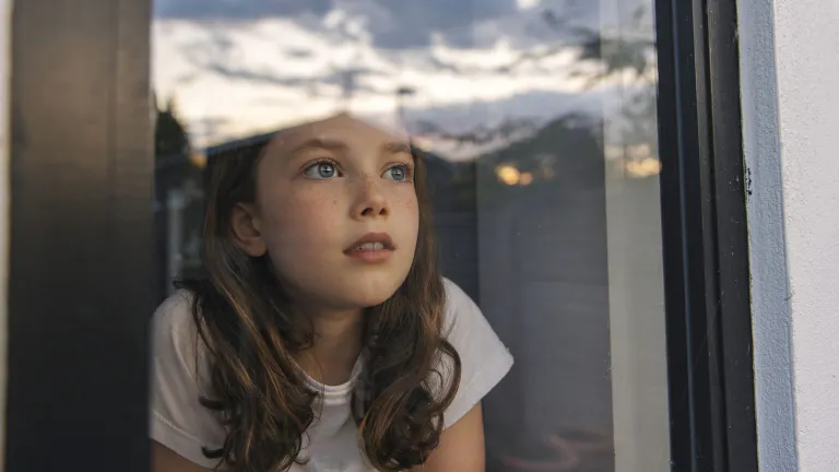 Uma menina olhando pela janela. Uma menina olhando pela janela.