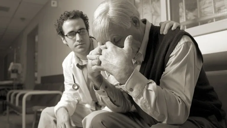 Um médico consolando uma pessoa enlutada.