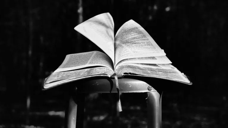 To understand scripture, we must remember the context and terms used in the verses. An open Bible on a metal stool.
