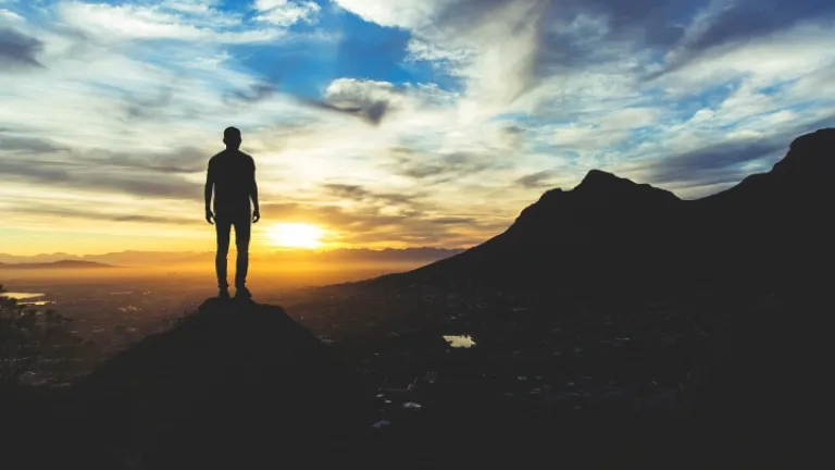 Seguir a Deus é o que tornará o mundo grande de novo! Isso acontecerá quando Jesus Cristo voltar para estabelecer o Reino de Deus na Terra para governar as nações. Um jovem em pé num penhasco