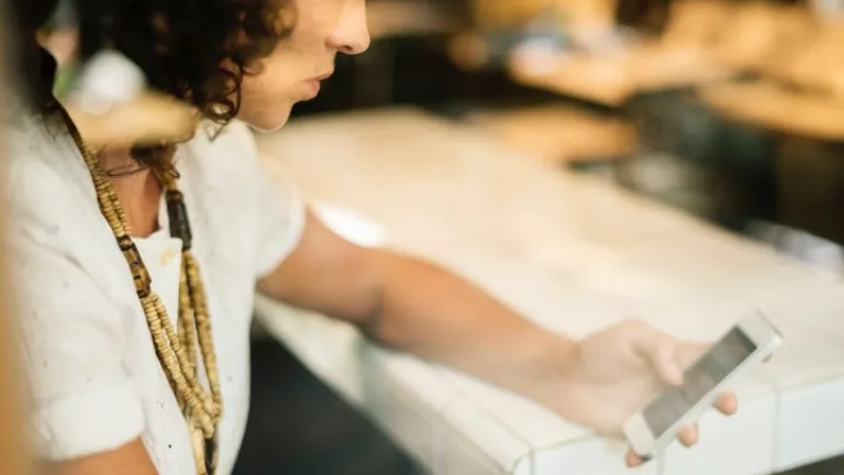 A notícia falsa é ao mesmo tempo simples e complexa ̶ simples porque vem de uma fonte e complexa, porque essa fonte pode imprevisivelmente conjurar muitas ideias socialmente inaceitáveis. Uma mulher olhando para o seu smartphone.