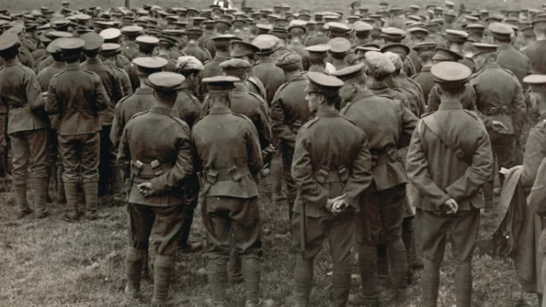 Uma fotografia velha de WWI que mostra uma missa no campo com os soldados que olham um padre.
