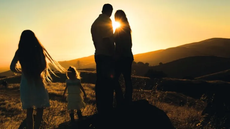 Uma família no campo ao pôr do sol.