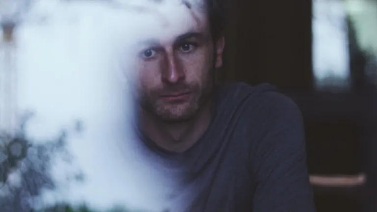 Olhando a um homem sentado à janela.