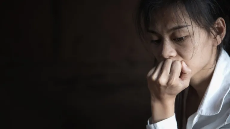 Uma mulher com o seu queixo na sua mão.