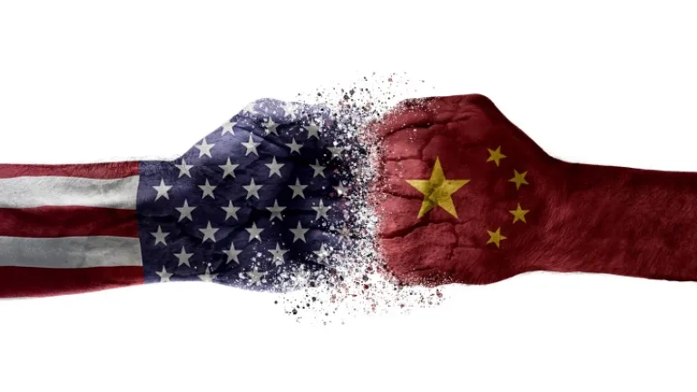 Será que as ameaças de guerra ou de feroz conflito econômico entre a China e a América e outros países estimularão uma União Europeia renovada a deixar de lado suas diferenças e se torne uma verdadeira força global dominante? Uma ilustração artística de dois punhos colidindo com imagens sobrepostas de bandeiras americanas e chinesas.