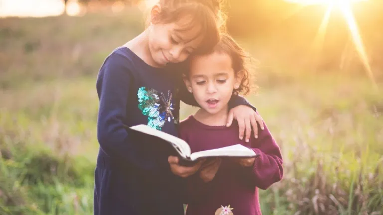 Duas moças lendo a Bíblia juntas.