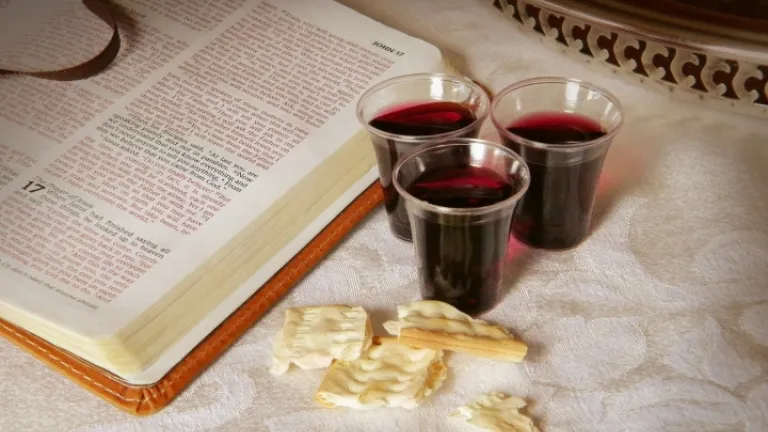 Uma Bíblia aberta, vinho de Páscoa e pedaços de pão asmo.