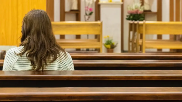 O Domingo de Páscoa e seus costumes não se originaram da Bíblia, mas dos rituais pagãos da fertilidade. Uma mulher sentada num banco de uma igreja.