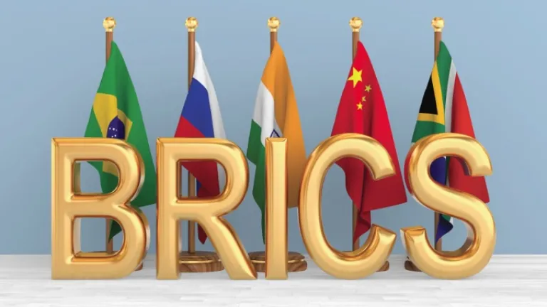 Letras da sigla BRICS com bandeiras dos países-membros ao fundo