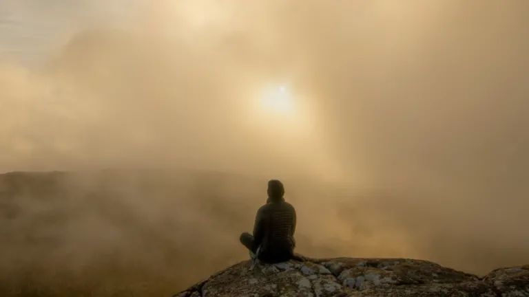Por que seria impossível entender um ensinamento supostamente fundamental e necessário sobre Deus? Será que há um grave erro na doutrina da trindade? Uma pessoa sentada em uma pedra no meio da neblina matinal.