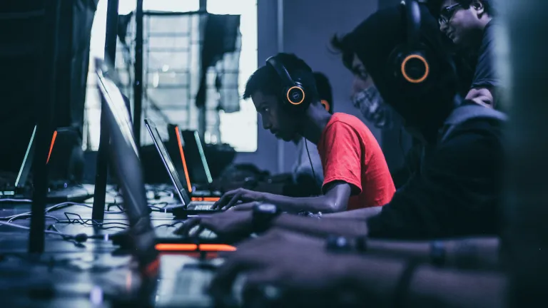 Pessoas jogando videogame em computadores.