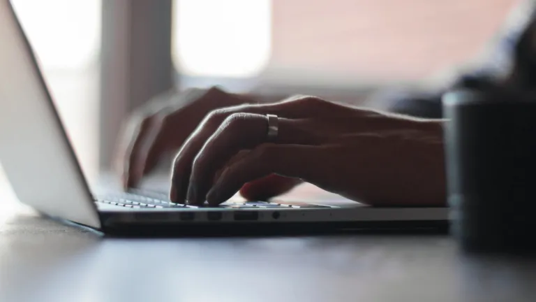 Mãos digitando na máquina de escrever.