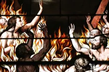 Une représentation artistique sur vitrail de personnes brûlant dans un incendie.