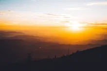 Raios de sol brilhando sobre colinas.