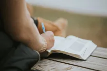 Uma pessoa escrevendo notas em uma Bíblia.