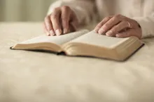 Uma mulher lendo uma Bíblia.