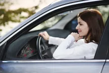Uma jovem dirigindo seu carro novo.
