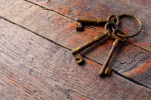 Três velhas chaves de esqueleto colocadas sobre uma velha mesa de madeira.