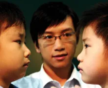 Um pai encorajando seus dois filhos a fazerem as pazes.