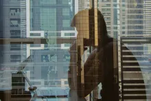 Reflexo de um homem pensativo enquanto olha para o computador.