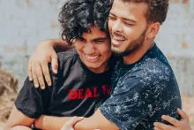 Caras felizes se abraçando casualmente.