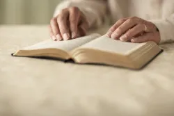 Uma mulher lendo a Bíblia.