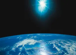 Ilustração fotográfica de uma luz brilhante acima da terra.