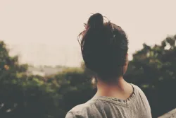 Uma mulher observando um vale.