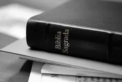 Bíblia empilhada sobre uma pilha de papéis.