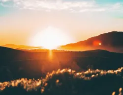 Um pôr-do-sol sobre colinas.