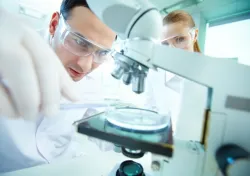 Cientista olhando por um microscópio.