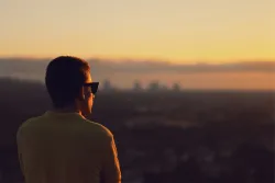 Um homem olhando para o nascer do sol.