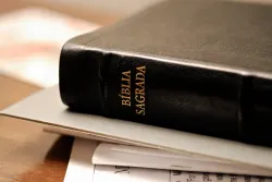 Uma Bíblia empilhada sobre papéis sobre uma mesa.
